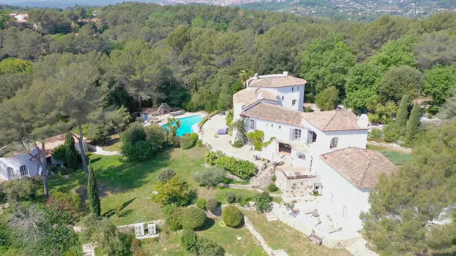 Vue aérienne du Domaine de Châteauneuf à Valbonne : la villa à tour ronde, la terrasse en pierre et la piscine dans le parc